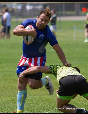 Blue and yellow ball carrier running upfield